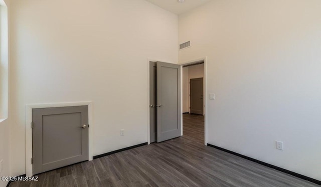 4270 E Broadway Blvd, Tucson, AZ 85711 - unfurnished room with baseboards, a high ceiling, visible vents, and wood finished floors