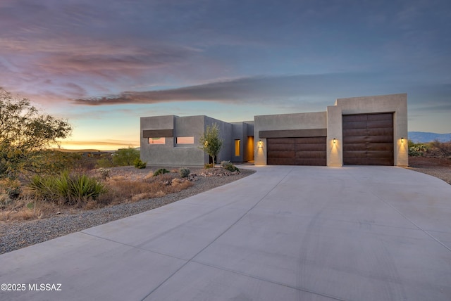 view of front of property with a garage, stucco siding, and concrete driveway