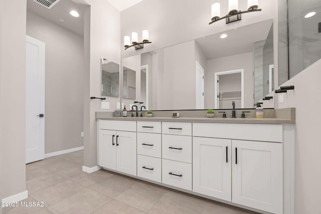 full bath with a sink, tile patterned flooring, double vanity, baseboards, and visible vents