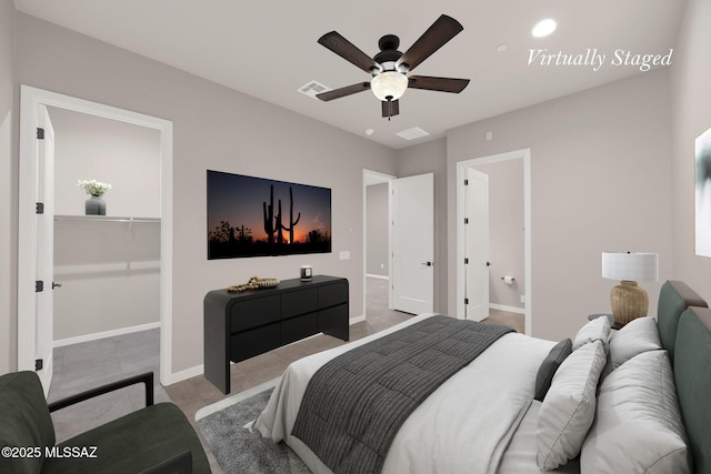 tiled bedroom featuring baseboards, a walk in closet, a ceiling fan, and visible vents