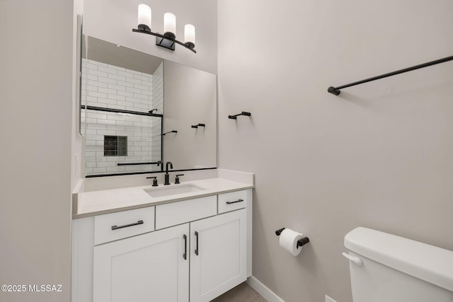 bathroom featuring vanity, baseboards, and toilet