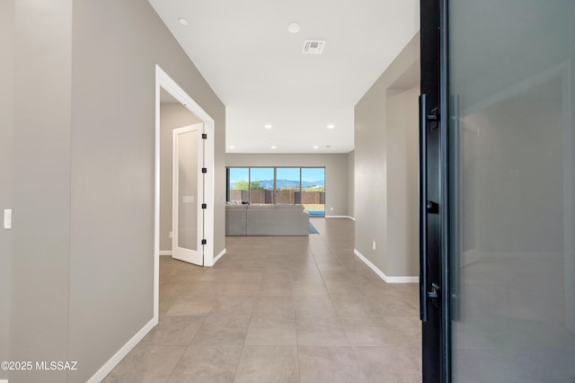 hallway featuring visible vents, recessed lighting, baseboards, and light tile patterned flooring