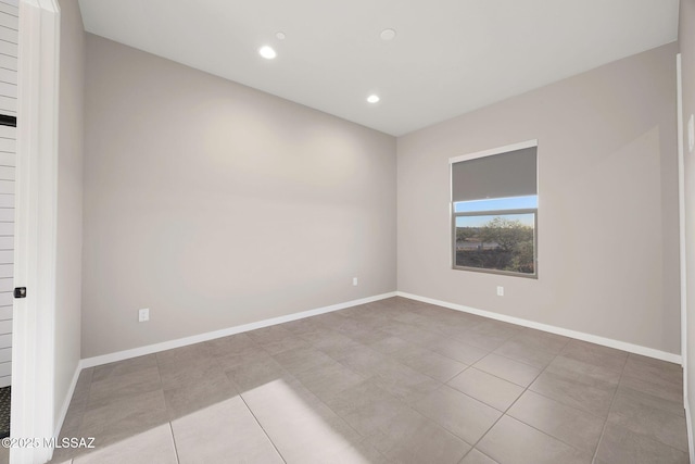 tiled empty room with baseboards and recessed lighting