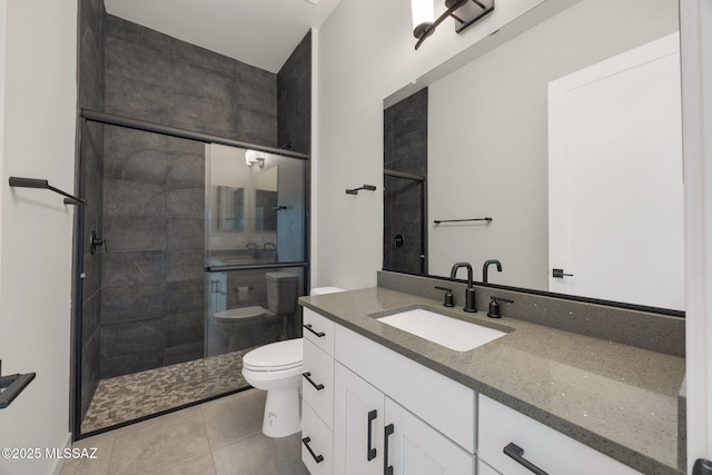 bathroom with toilet, tile patterned floors, a shower stall, and vanity
