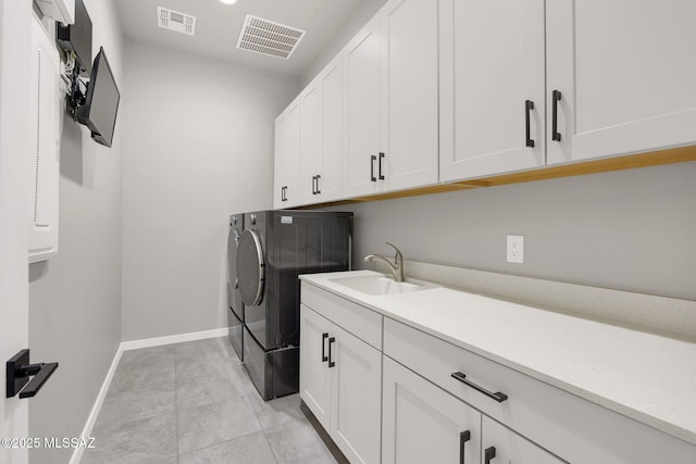 laundry room with visible vents, a sink, cabinet space, and washing machine and dryer