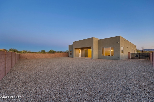 rear view of property with a fenced backyard and stucco siding