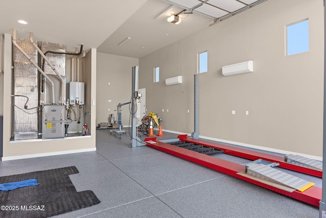 workout room featuring baseboards, tankless water heater, a wall mounted AC, and a wealth of natural light