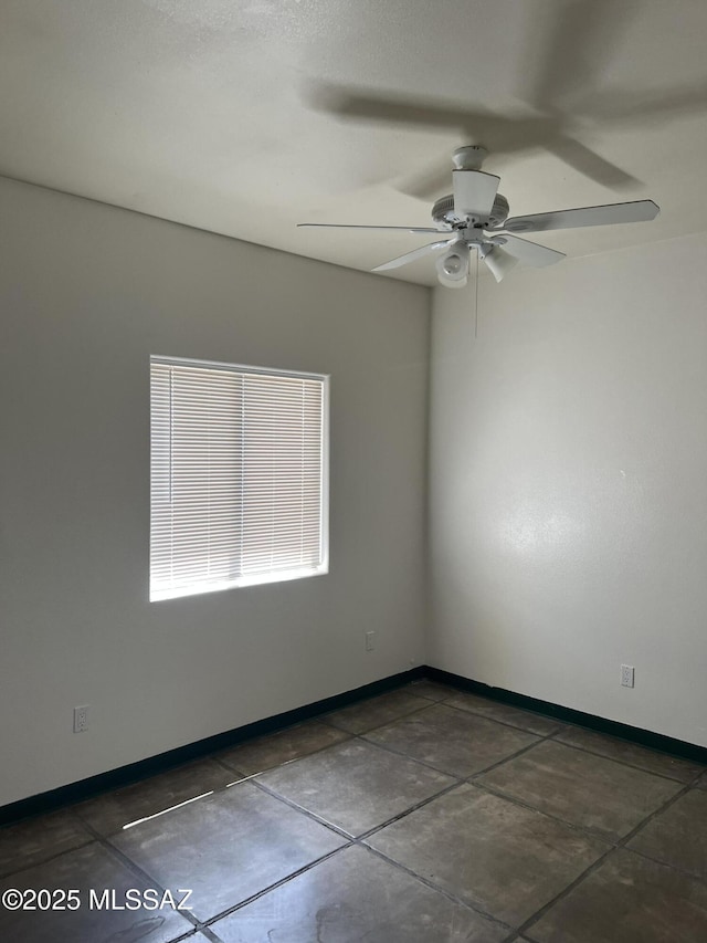 empty room featuring a ceiling fan and baseboards