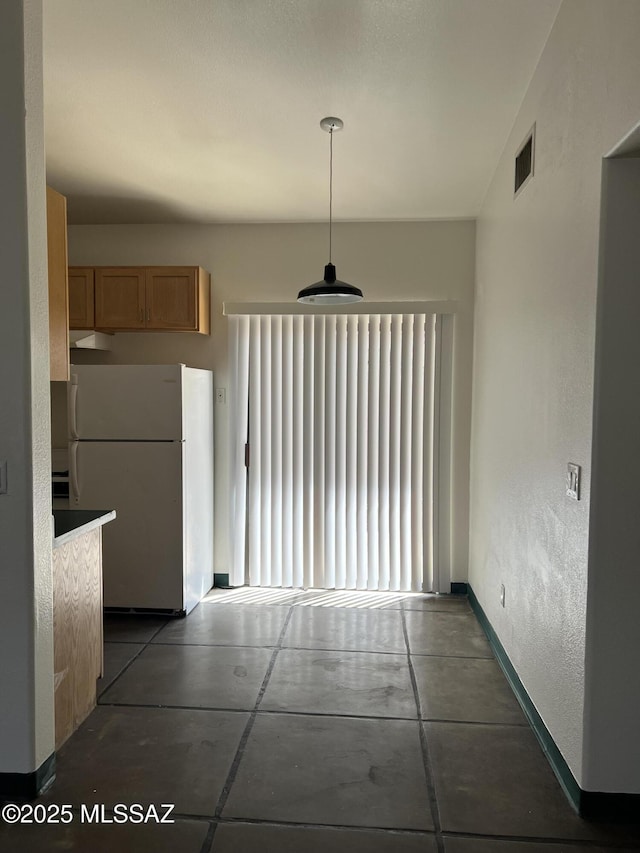unfurnished dining area with baseboards and visible vents