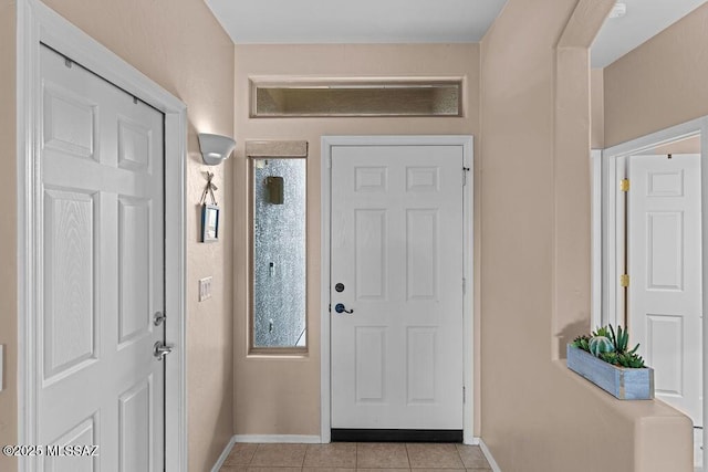 foyer with light tile patterned floors and baseboards