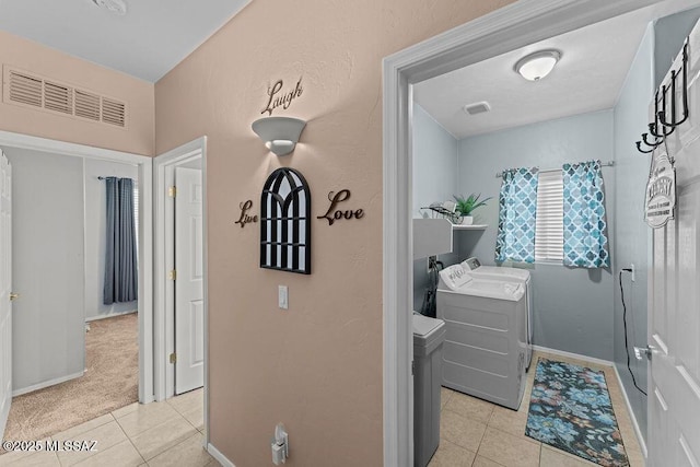 interior space featuring washer and dryer, laundry area, baseboards, light tile patterned floors, and visible vents