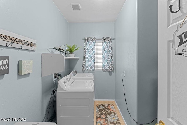 washroom with baseboards, laundry area, independent washer and dryer, and visible vents