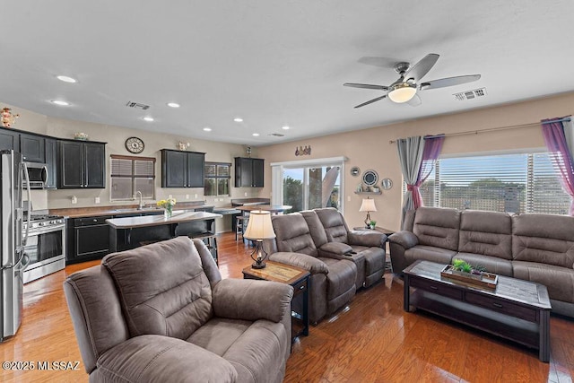 living room with recessed lighting, ceiling fan, and visible vents