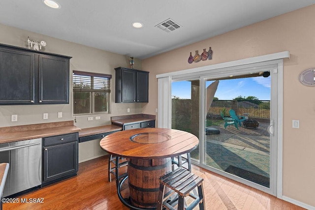 kitchen featuring dishwasher, dark cabinetry, recessed lighting, light wood-type flooring, and visible vents