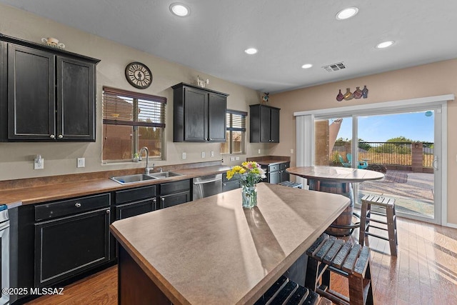 kitchen with a sink, dishwasher, dark cabinetry, recessed lighting, and visible vents