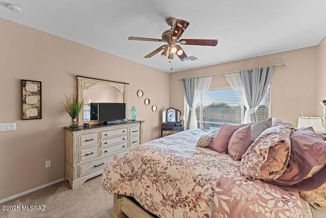 bedroom with visible vents, a ceiling fan, baseboards, and light carpet