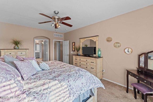 bedroom featuring visible vents, baseboards, ceiling fan, light colored carpet, and arched walkways