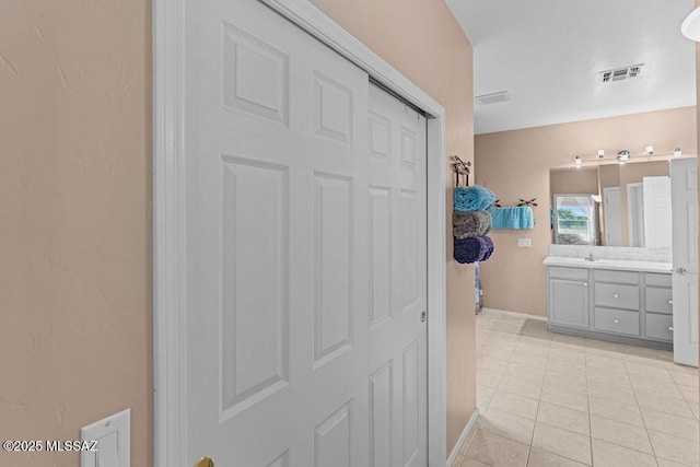 bathroom with baseboards, visible vents, tile patterned floors, and vanity