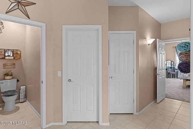 hall with baseboards and light tile patterned floors