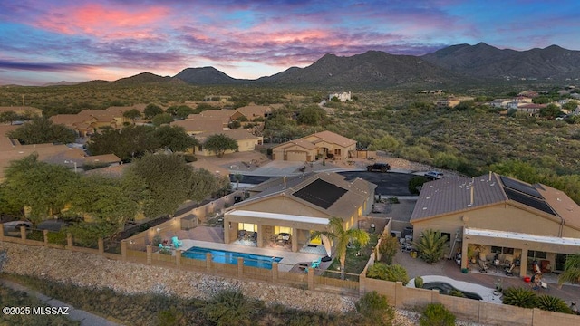 aerial view at dusk featuring a mountain view