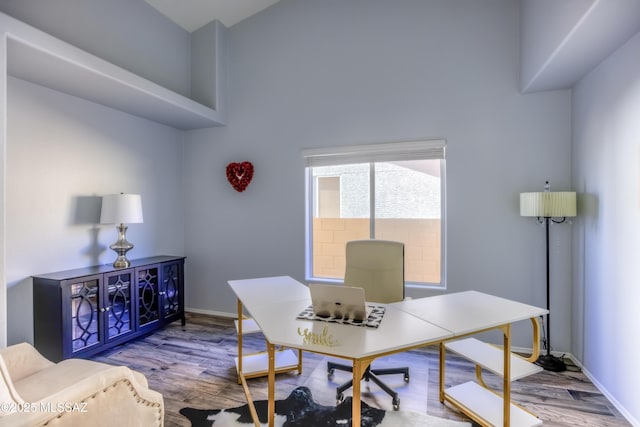 1707 W Sunridge Dr, Tucson, AZ 85704 - home office featuring baseboards, wood finished floors, and a high ceiling