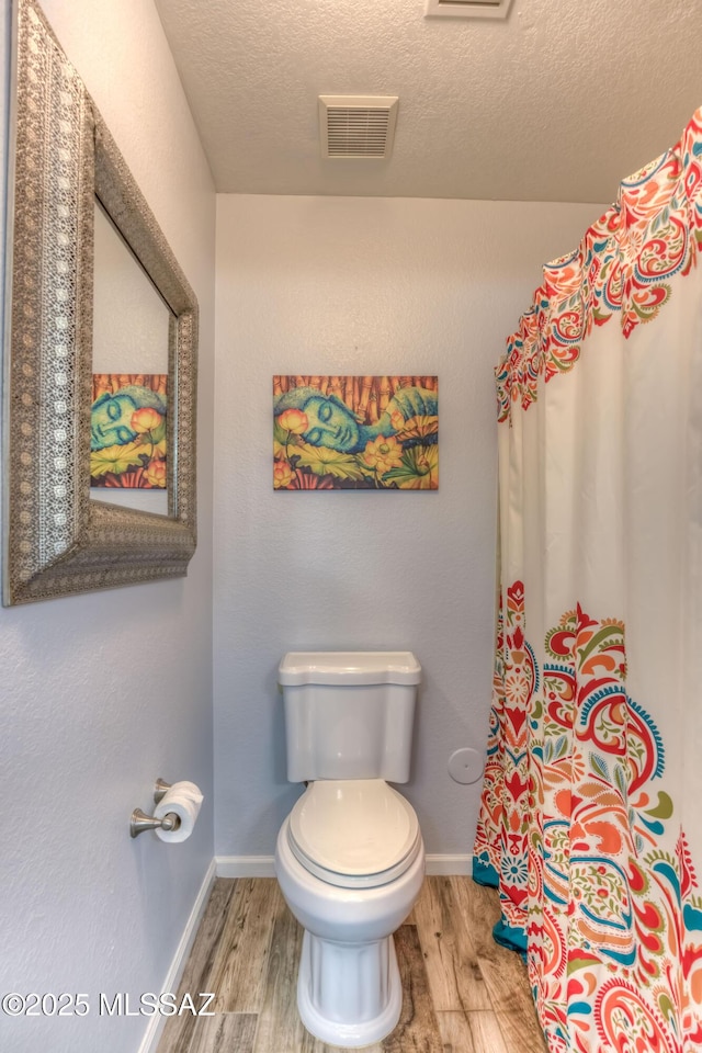1707 W Sunridge Dr, Tucson, AZ 85704 - bathroom with visible vents, a textured ceiling, wood finished floors, and toilet
