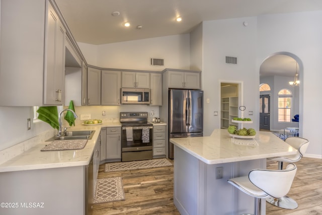 1707 W Sunridge Dr, Tucson, AZ 85704 - kitchen with visible vents, arched walkways, gray cabinets, and stainless steel appliances