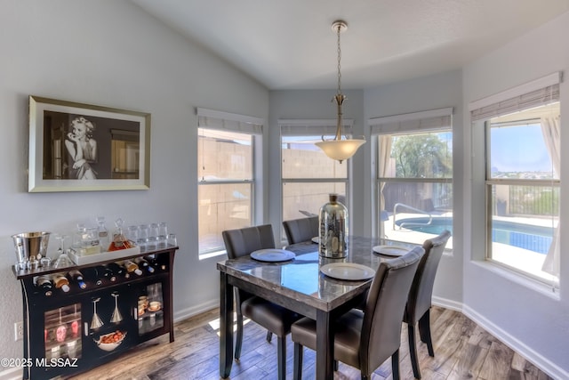 1707 W Sunridge Dr, Tucson, AZ 85704 - dining space with baseboards, vaulted ceiling, and wood finished floors