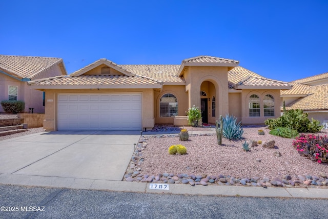 1707 W Sunridge Dr, Tucson, AZ 85704 - mediterranean / spanish home with a tiled roof, stucco siding, driveway, and a garage