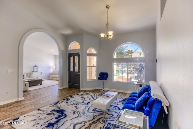 1707 W Sunridge Dr, Tucson, AZ 85704 - foyer entrance featuring an inviting chandelier, arched walkways, baseboards, and wood finished floors