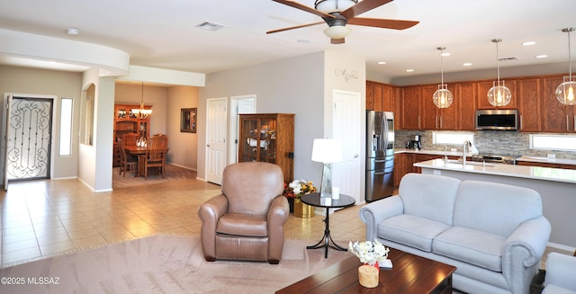 living room featuring recessed lighting, baseboards, visible vents, and ceiling fan with notable chandelier