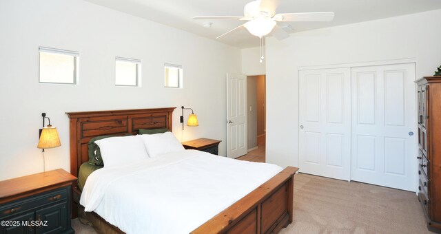 bedroom with multiple windows, a ceiling fan, a closet, and light colored carpet