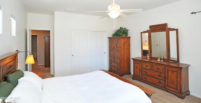 bedroom with ceiling fan, light carpet, a closet, and visible vents