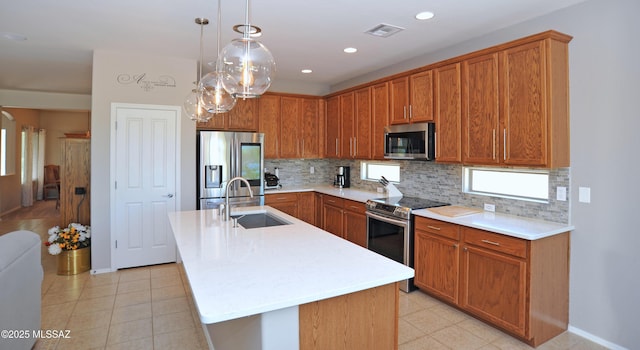kitchen with appliances with stainless steel finishes, a sink, light countertops, decorative backsplash, and visible vents