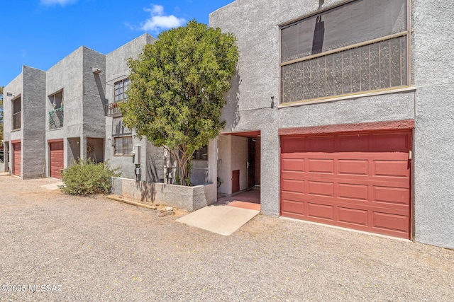 1525 N Bryant Ave, Tucson, AZ 85712 - view of front facade with stucco siding, an attached garage, and driveway