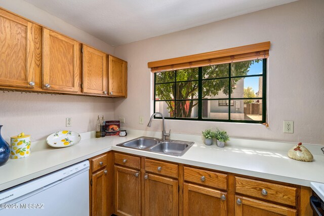 1525 N Bryant Ave, Tucson, AZ 85712 - kitchen featuring light countertops, white dishwasher, brown cabinets, and a sink