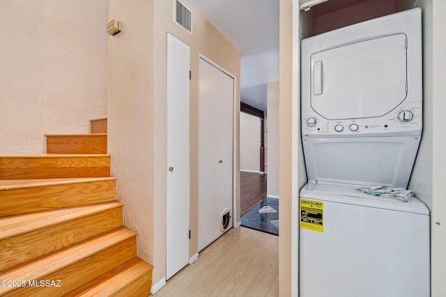 1525 N Bryant Ave, Tucson, AZ 85712 - laundry room featuring stacked washing maching and dryer, baseboards, wood finished floors, and visible vents