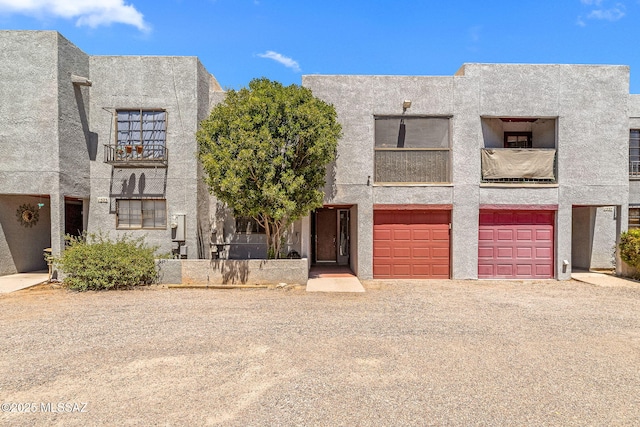 1525 N Bryant Ave, Tucson, AZ 85712 - view of front of home featuring a garage, stucco siding, driveway, and a balcony