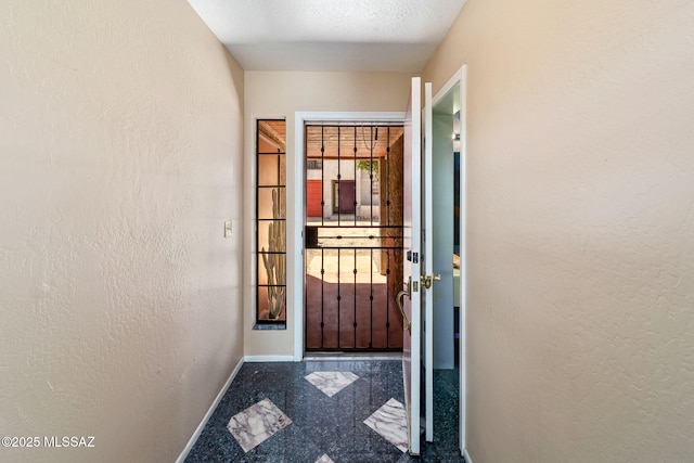 1525 N Bryant Ave, Tucson, AZ 85712 - doorway featuring baseboards, a textured wall, and granite finish floor