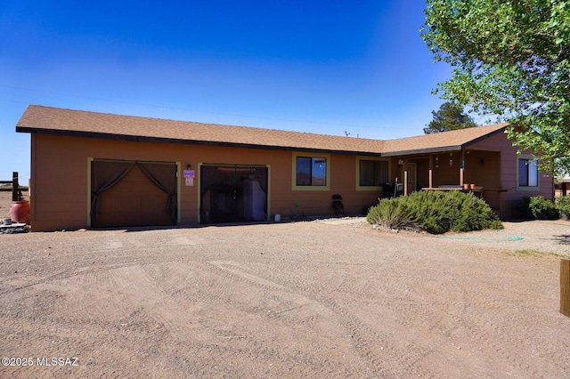 single story home featuring driveway, a garage, and roof with shingles