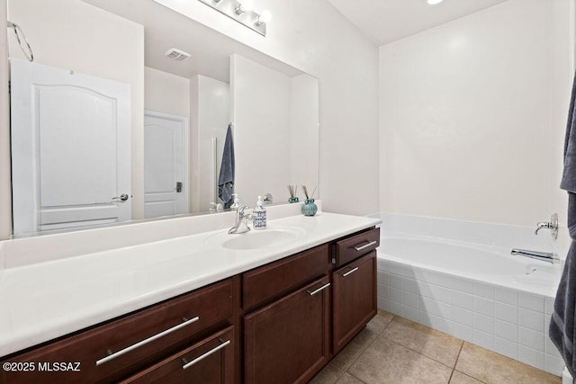 bathroom with a garden tub, tile patterned floors, visible vents, and vanity