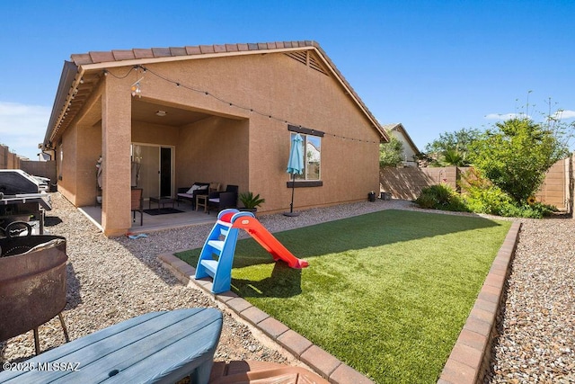 back of property featuring a fenced backyard, stucco siding, a yard, and a patio area