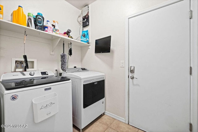 laundry room with washing machine and clothes dryer, laundry area, baseboards, and light tile patterned floors