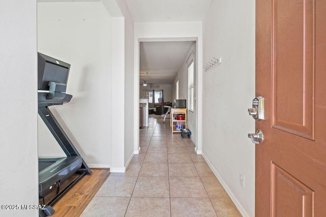 foyer entrance with light tile patterned floors, baseboards, and ceiling fan