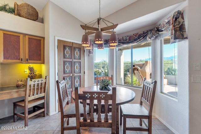 dining space featuring light tile patterned floors, baseboards, vaulted ceiling, and a notable chandelier