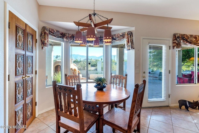 dining room with plenty of natural light, light tile patterned flooring, and a chandelier