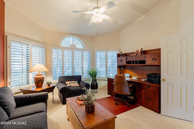 carpeted office space with a ceiling fan and vaulted ceiling