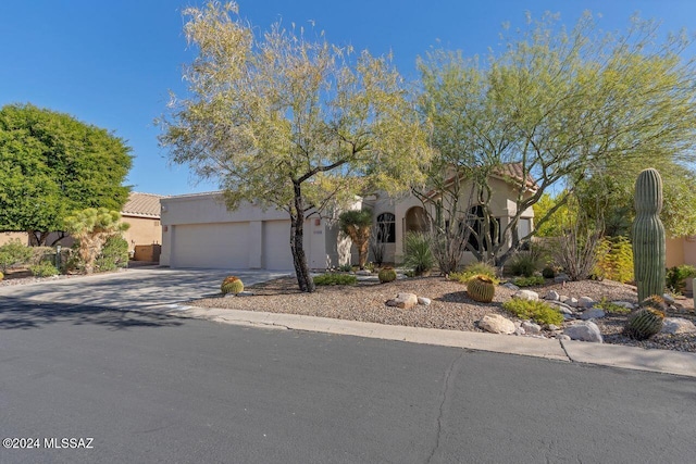 mediterranean / spanish house featuring an attached garage, concrete driveway, and stucco siding