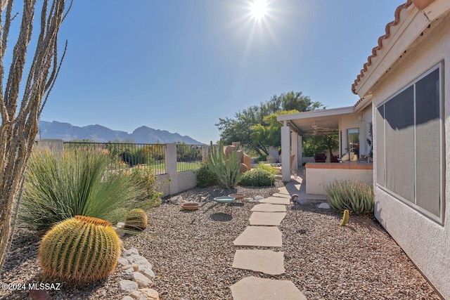 view of yard featuring a mountain view and fence