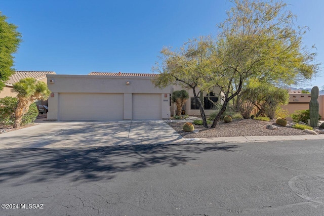 view of front of home featuring an attached garage, stucco siding, driveway, and a tile roof